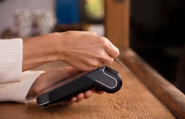 Young woman doing process payment with the bill or invoice on the POS cash terminal in a shop