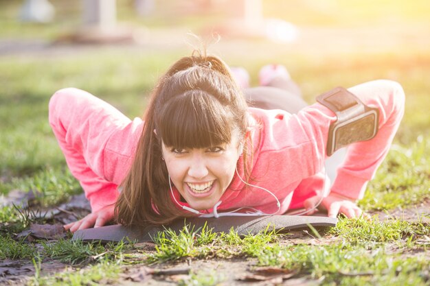 公園で腕立て伏せ運動をしている若い女性。