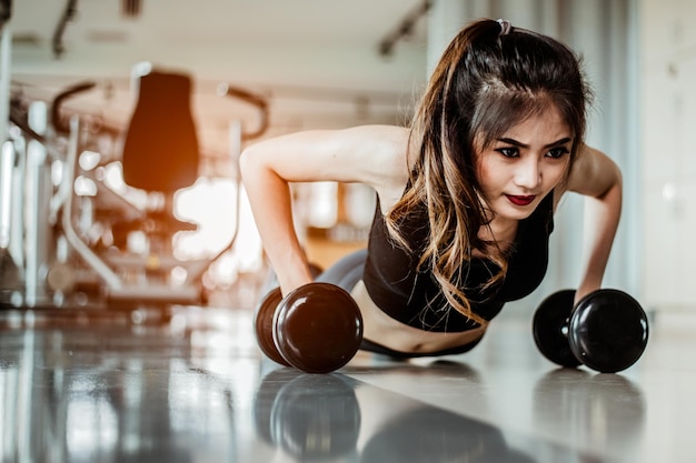 ジムで腕立て伏せをしている若い女性