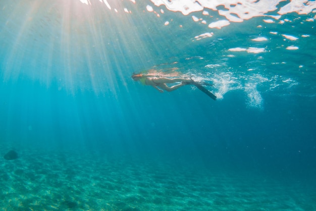 地中海の水晶の水でシュノーケリングをしている若い女性