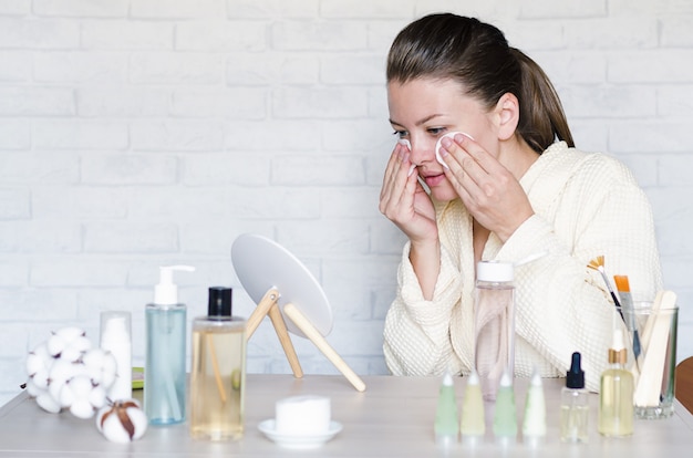 young woman doing spa, wellness treatments, procedures at home using natural cosmetics.