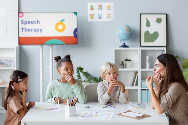 Photo young woman doing speech therapy with children