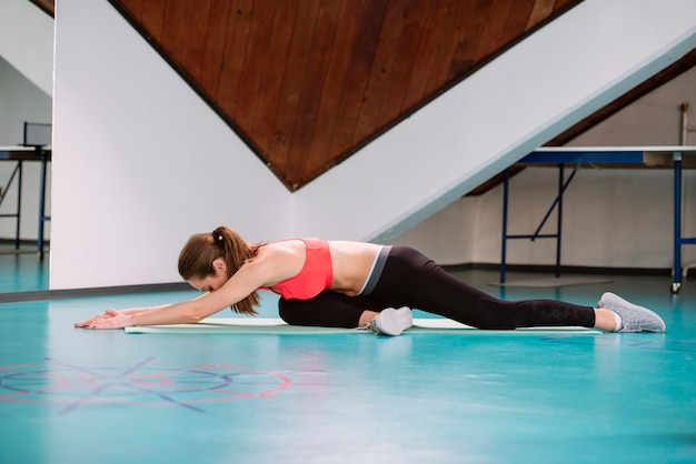 Young woman doing stretching exercises in the gym