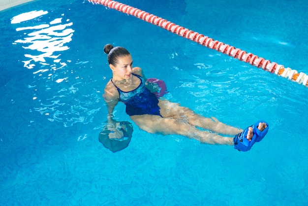 Young woman doing water aerobics in indoor pool, sporting concept