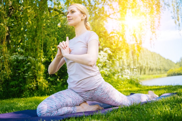 Young woman doing yoga asana in park girl stretching exercise in yoga position