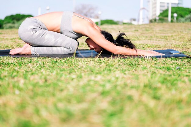 Young woman doing yoga back stretching exercises