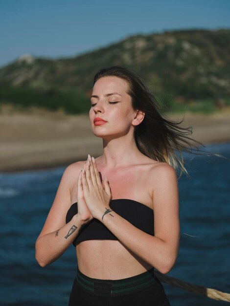 Photo young woman doing yoga on the beach