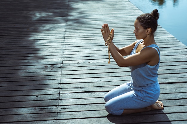 Photo young woman doing yoga by the lake