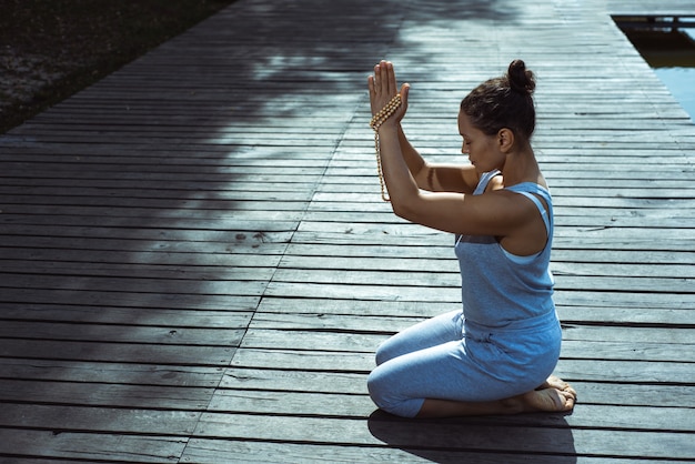 Photo young woman doing yoga by the lake