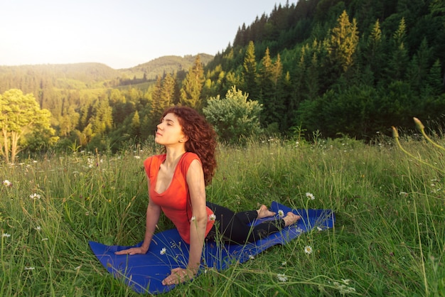 Young woman doing yoga exercises in the nature