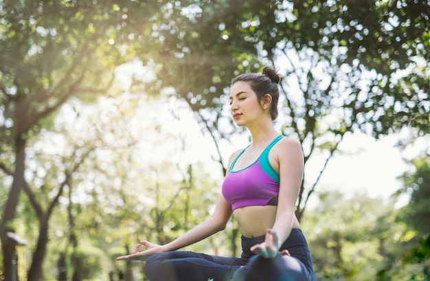 Foto giovane donna che fa yoga nella sosta di mattina