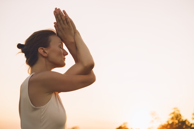 Young woman doing yoga on nature Girl is practicing yoga outdoors