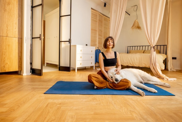 Young woman doing yoga with her dog