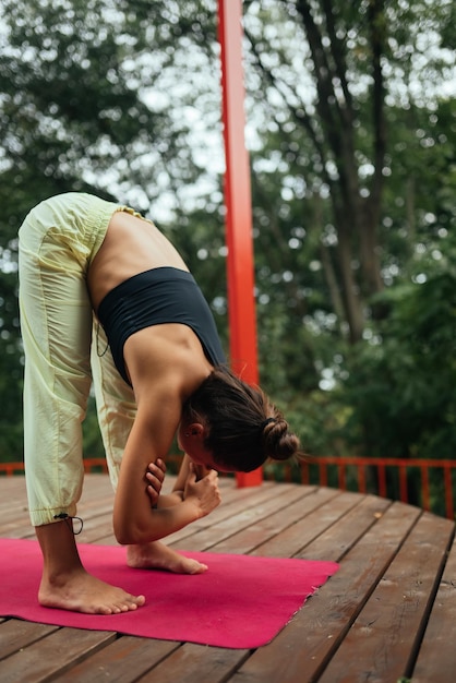 A young woman in doing yoga in the yard