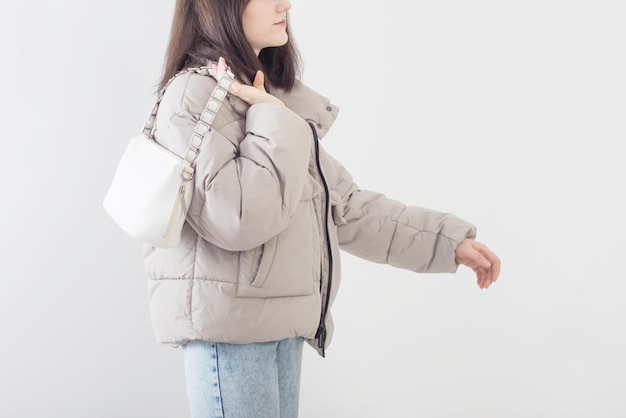 Young woman  in down jacket on white background