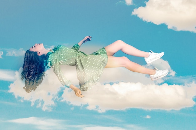 Photo young woman in dress flying and sleep in the sky