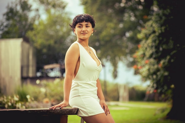 Young woman in dress possing at summer background