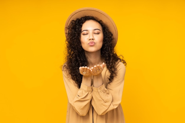 Young woman in dress on yellow background