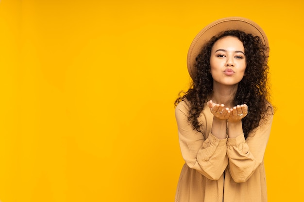 Young woman in dress on yellow background