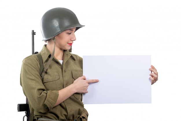 Young woman dressed in American ww2 military uniform showing empty blank signboard