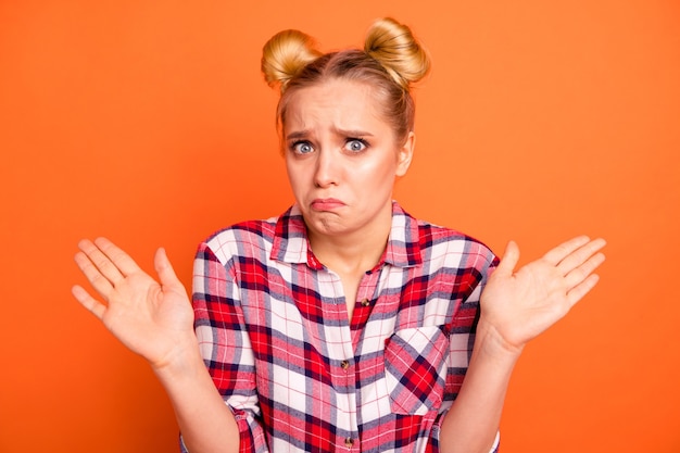 Photo young woman dressed in a plaid checked shirt isolated on orange