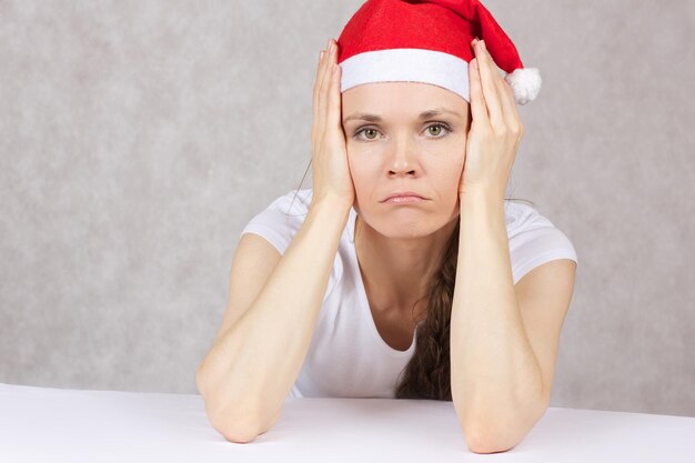 Photo young woman dressed in santas hat. closeup