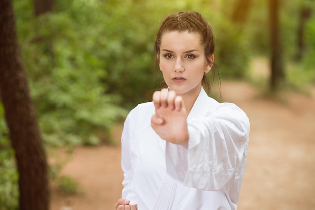 Young Woman Dressed In Traditional Kimono Practicing Her Karate Moves in Wooded Forest Area  Black Belt