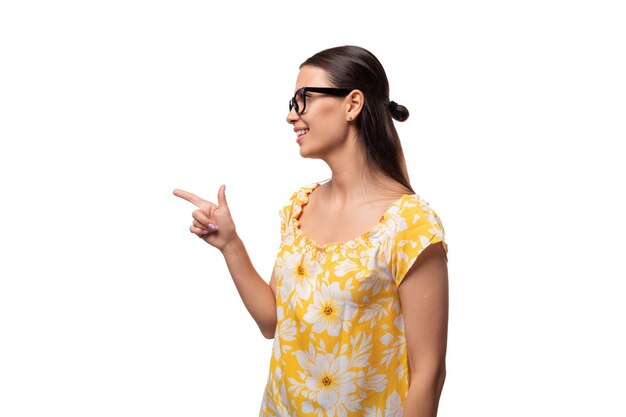 Young woman dressed in a yellow sundress and with glasses for vision is surprised on a white