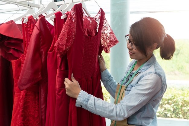 Young woman dressmaker checking the dresses