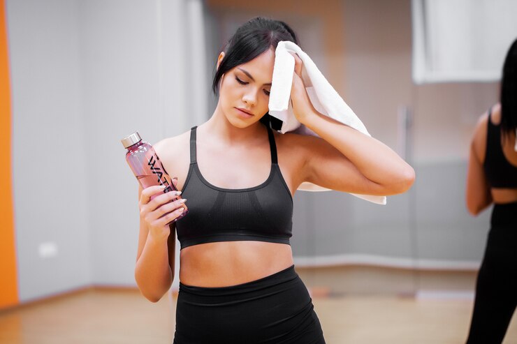 Photo young woman drink clean water in fitness gym