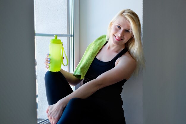 Young woman drink water in the gym