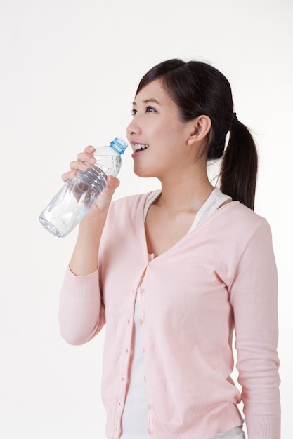 Young woman drink water on white background.