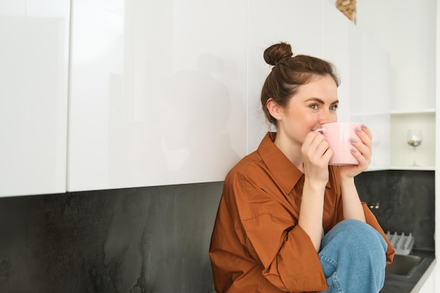 Фото Молодая женщина пьет кофе дома.