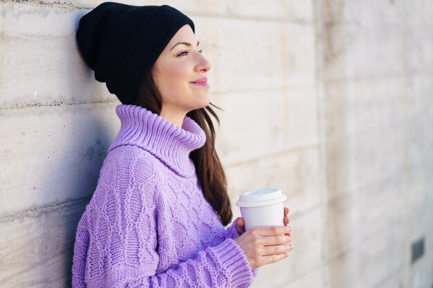 Young woman drinking coffee cup in winter