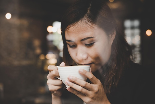 写真 コーヒーカップを飲んでいる若い女性