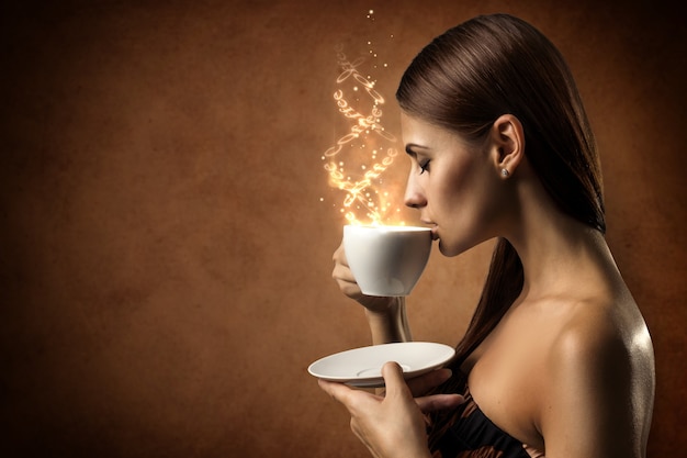 Foto giovane donna che beve caffè dalla tazza con testo magico galleggiante