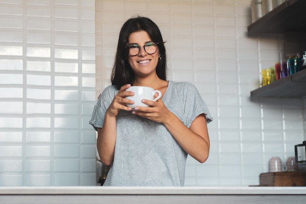 若い女性が自宅でコーヒーを飲む