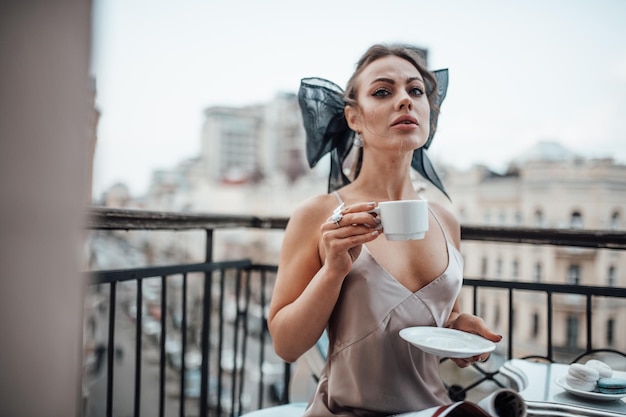 写真 街でコーヒーを飲んでいる若い女性