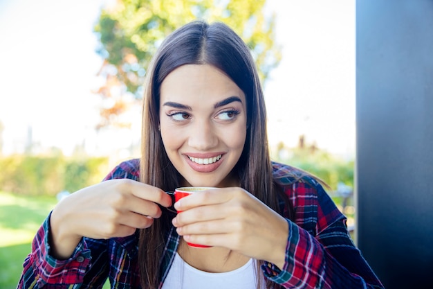 Young woman drinking coffee in the park