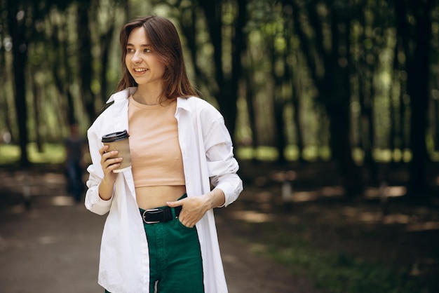 Young woman drinking coffee in park