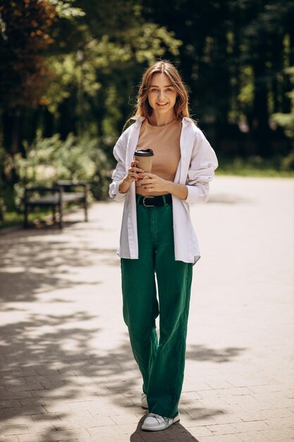 Young woman drinking coffee in park