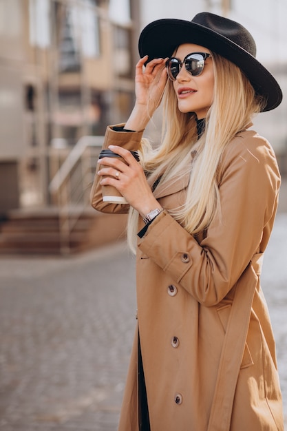 Giovane donna che beve caffè in città