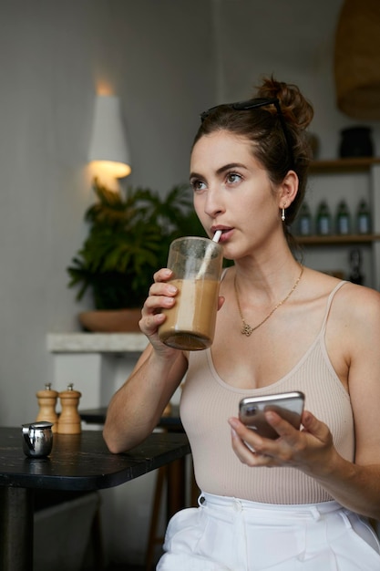 Young woman drinking coffee while sitting in cafe
