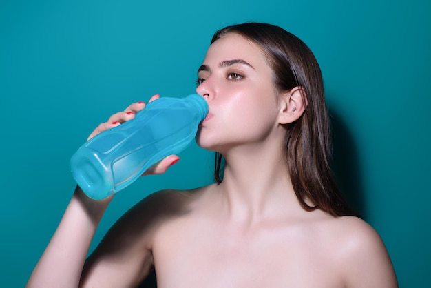 スタジオの背景に隔離された新鮮な水を飲む若い女性グラスを持った喉が渇いた女性