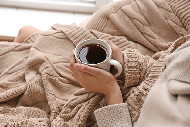 Young woman drinking hot tea at home