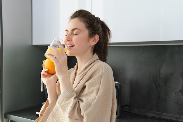 写真 家でジュースを飲んでいる若い女性