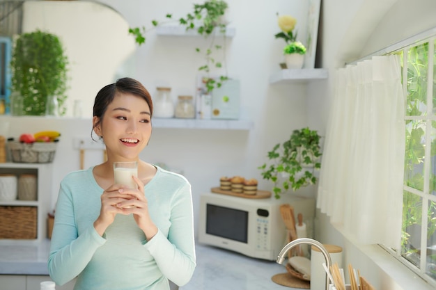 Young woman drinking milk and looking on copy space