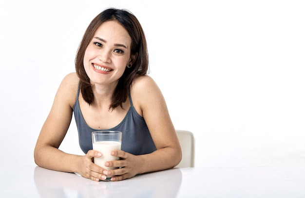 Young woman drinking milk on table