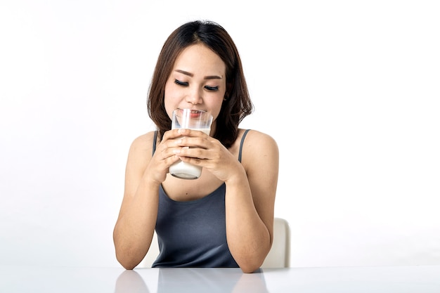 テーブルの上に牛乳を飲む若い女性