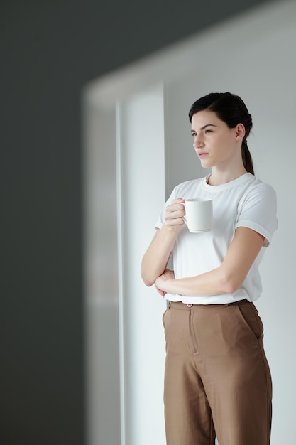 朝のコーヒーを飲む若い女性